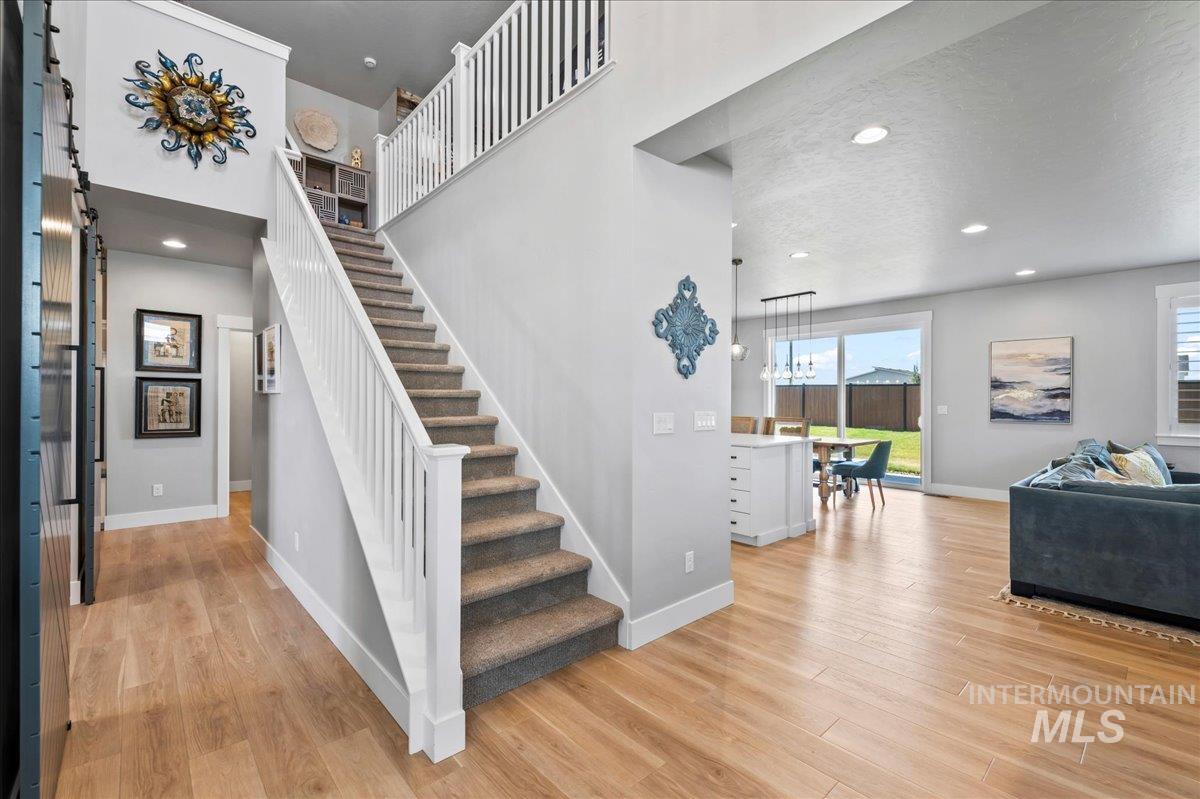Staircase featuring wood finished floors, plenty of natural light, and a barn door