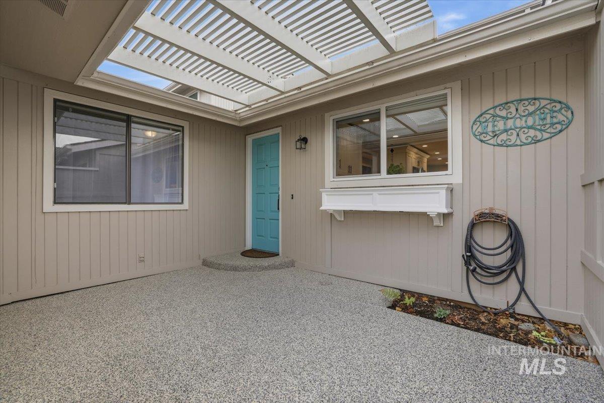 Doorway to property with a pergola