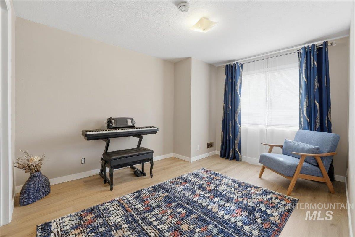 Living area with light wood-style flooring and a textured ceiling