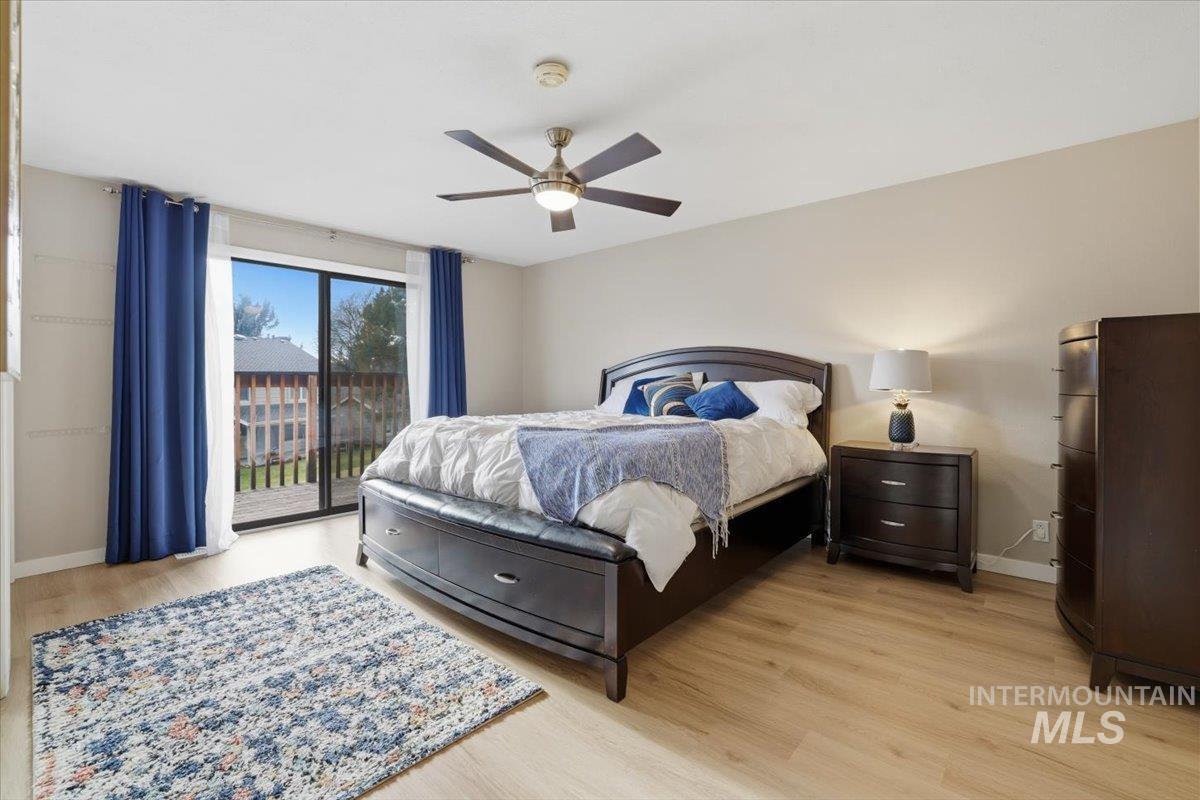 Bedroom with access to exterior, light wood finished floors, and a ceiling fan