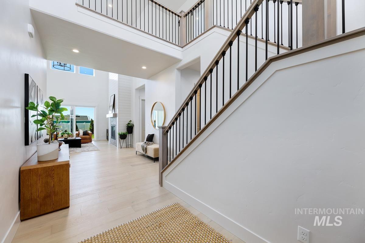 Entrance foyer with a high ceiling, stairs, light wood-style flooring, and recessed lighting