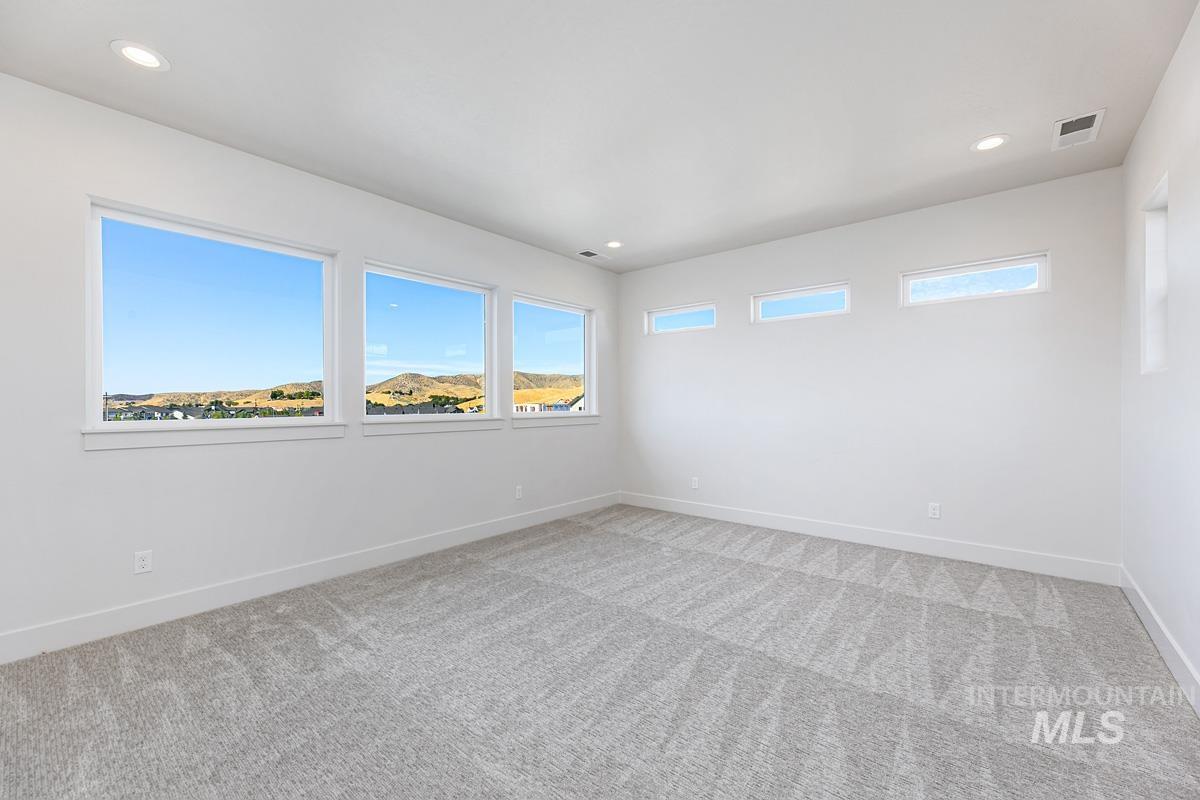 Empty room featuring recessed lighting and light colored carpet