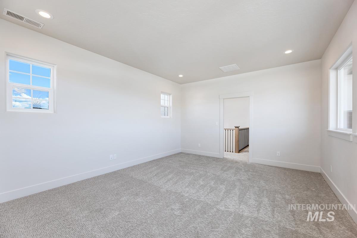 Spare room with healthy amount of natural light, recessed lighting, and light colored carpet