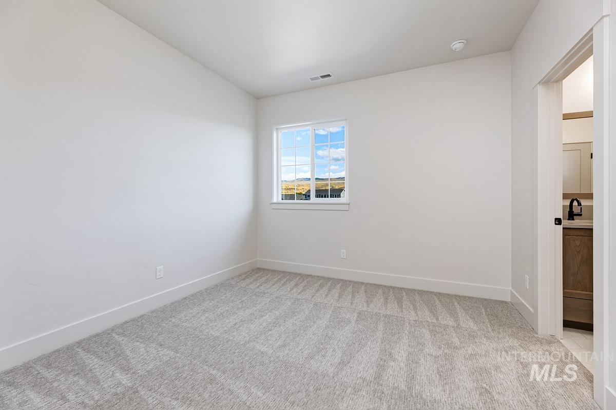 Spare room featuring light carpet and baseboards