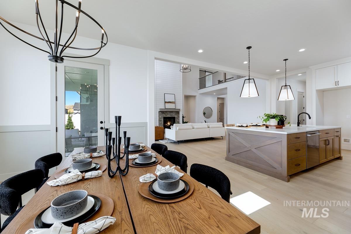 Dining room featuring a fireplace, a chandelier, light wood-type flooring, and recessed lighting