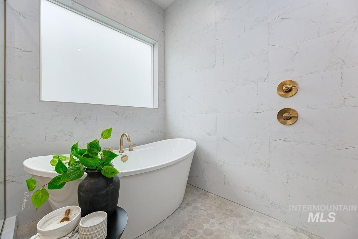Full bath with a freestanding tub and tile walls