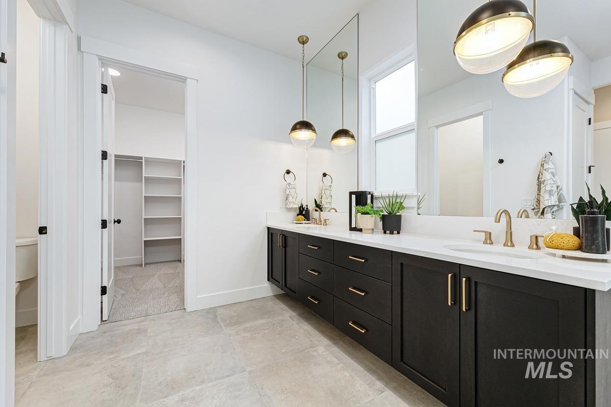 Bathroom featuring double vanity and a spacious closet