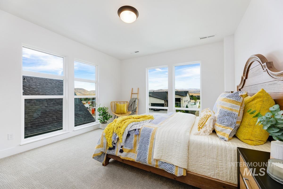 Bedroom with carpet and multiple windows