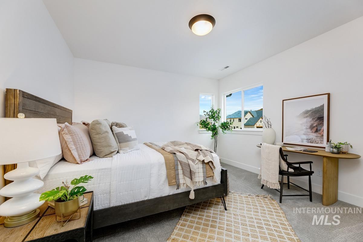 Bedroom with light colored carpet and baseboards