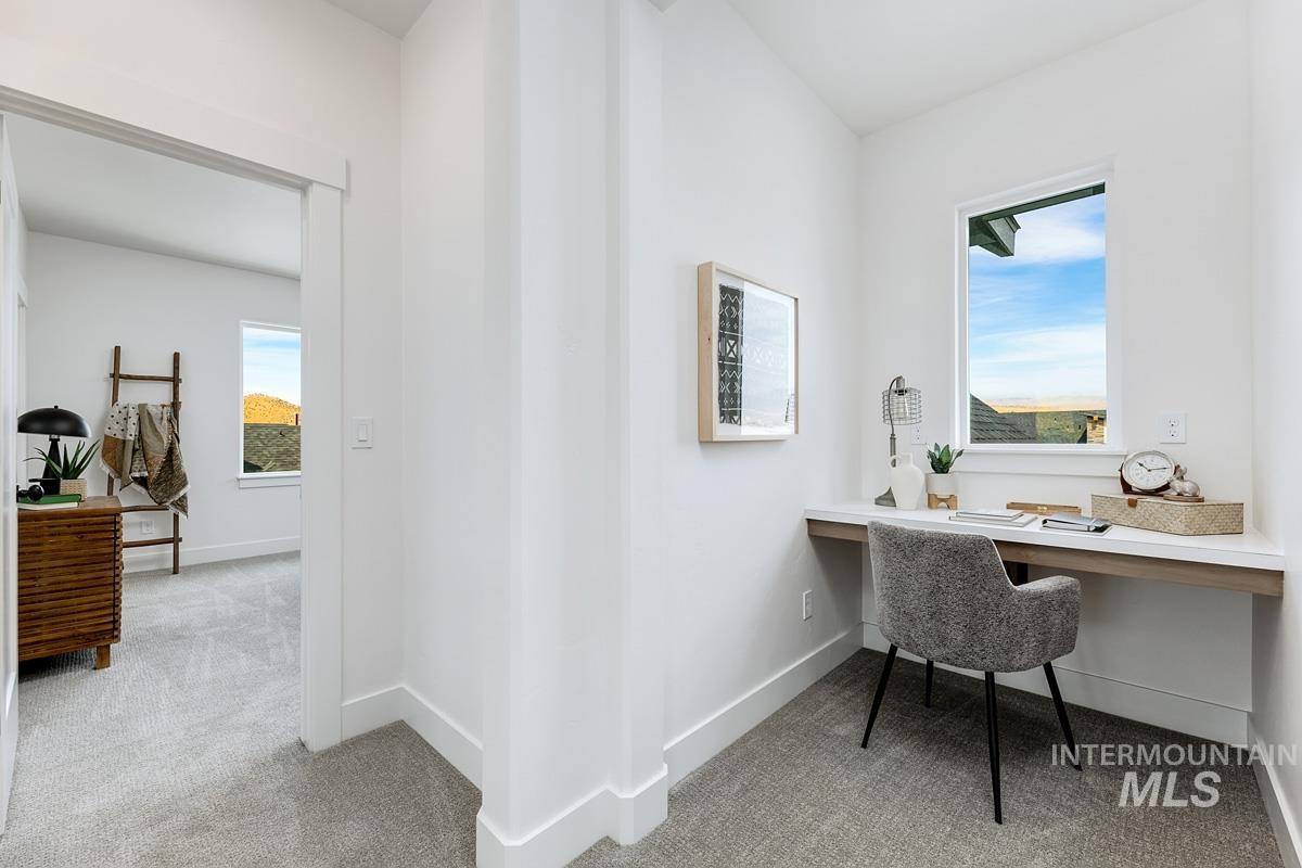 Office space featuring light colored carpet and built in desk