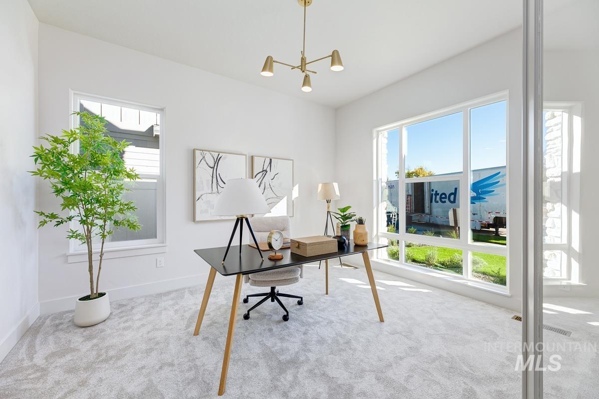 Office area featuring carpet flooring, plenty of natural light, and a chandelier