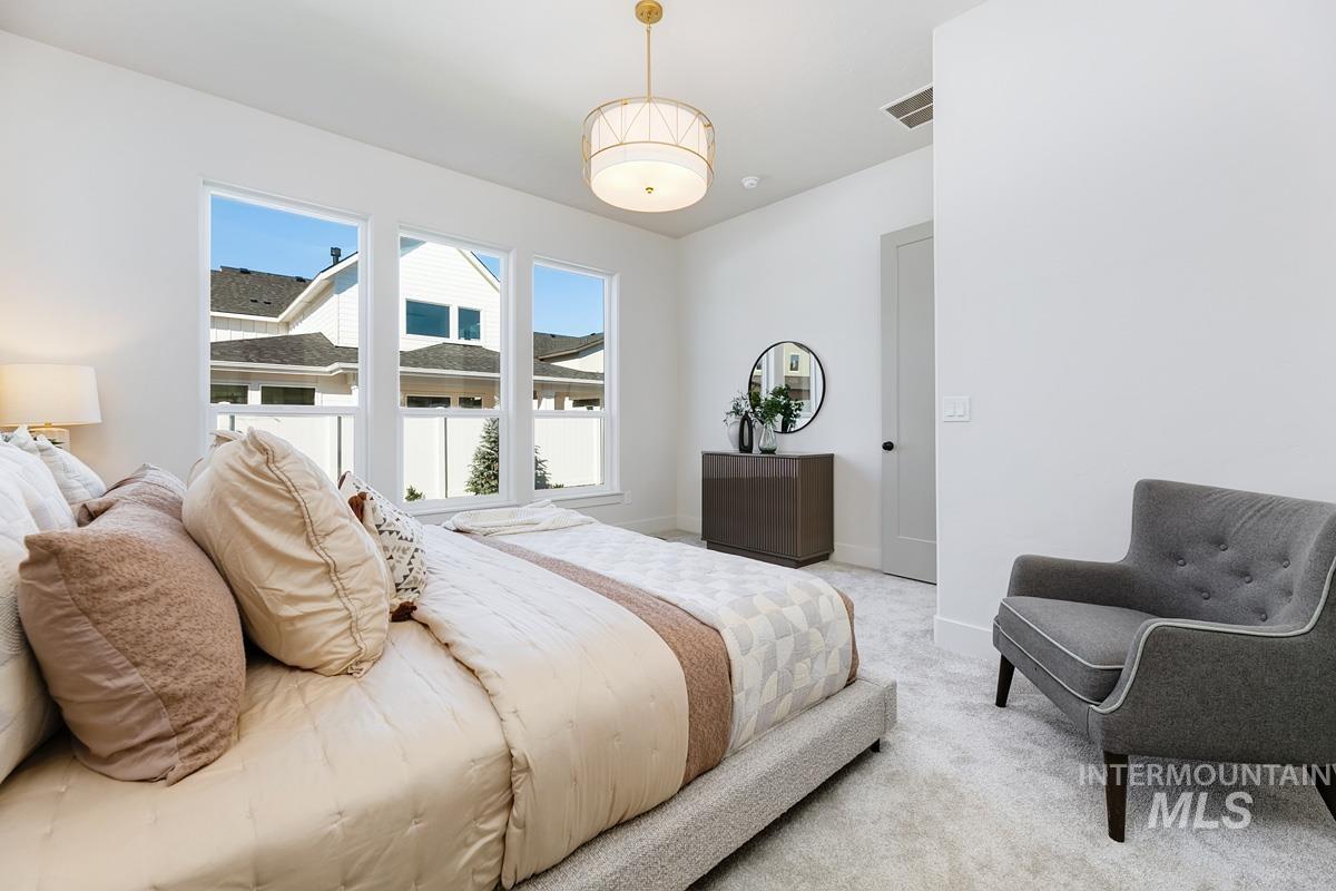 Bedroom featuring light carpet and baseboards
