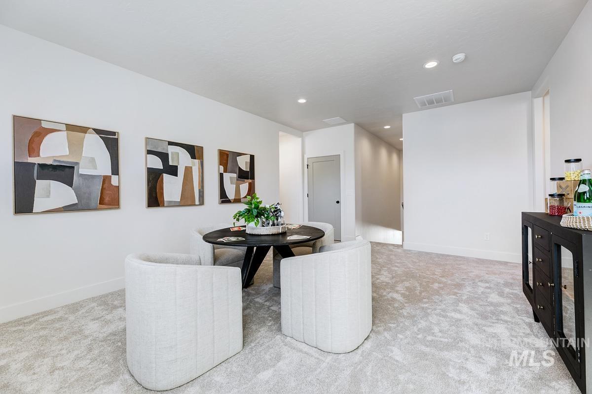 Dining room with light carpet and recessed lighting