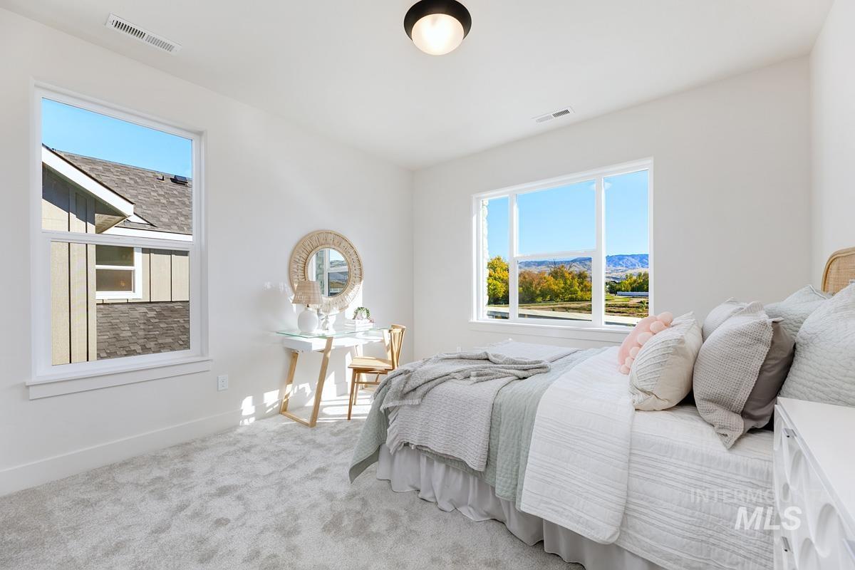 Carpeted bedroom with multiple windows and a mountain view