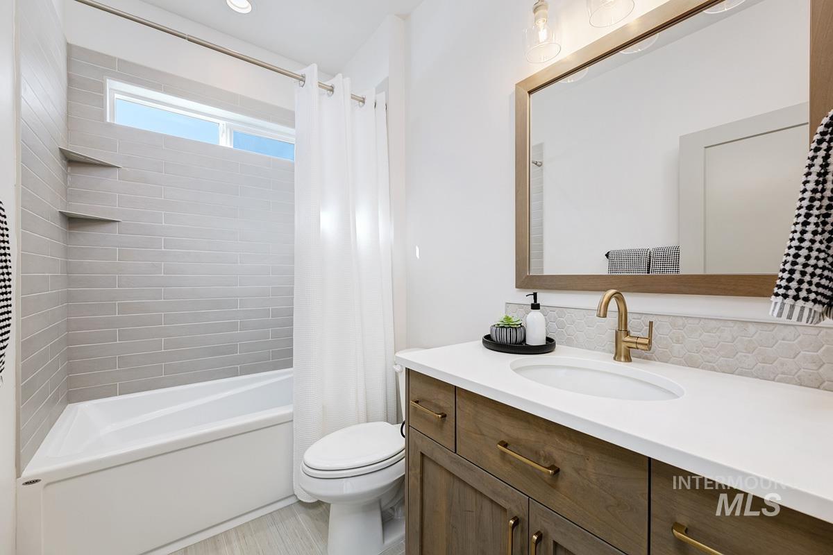 Bathroom featuring shower / bath combination with curtain and vanity