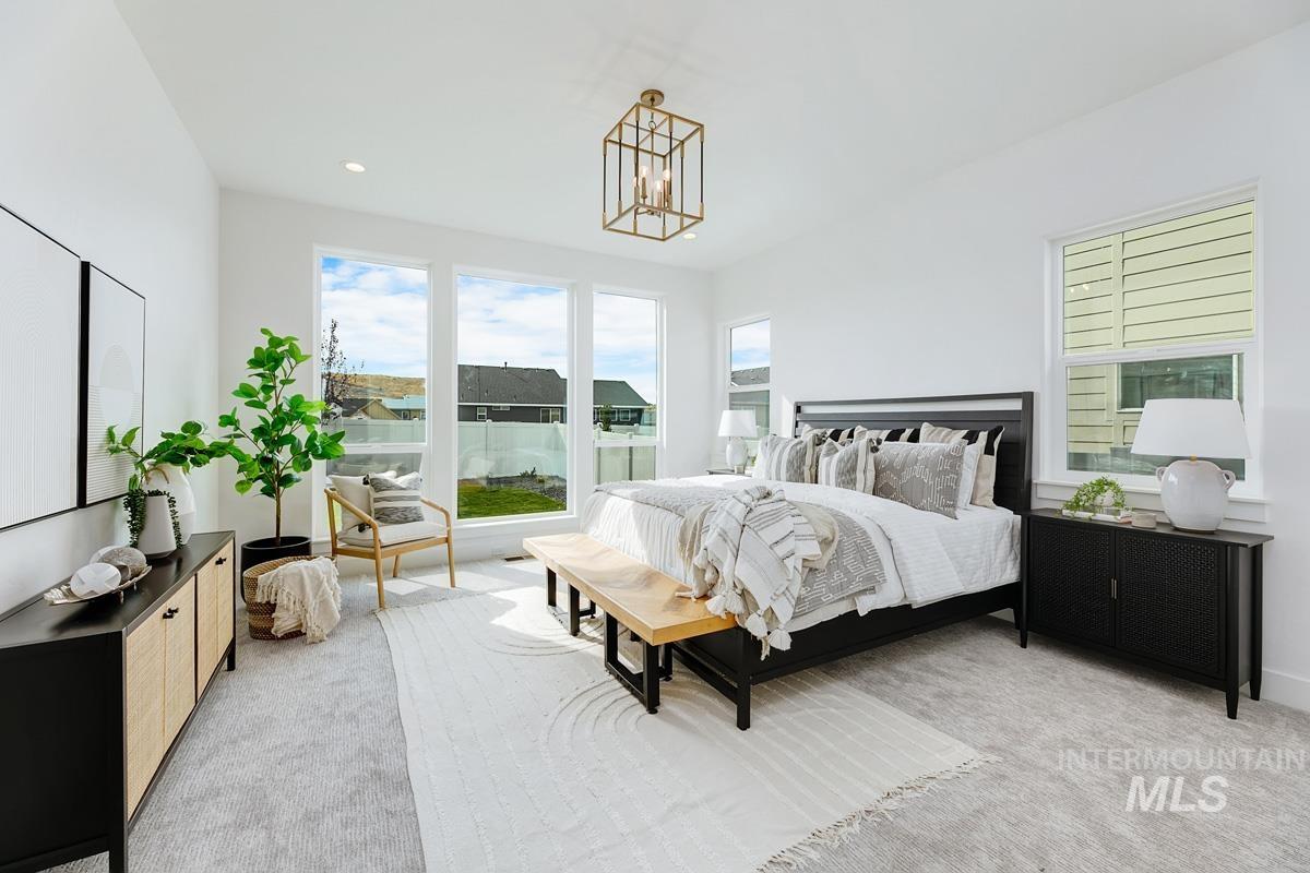 Carpeted bedroom featuring multiple windows and recessed lighting