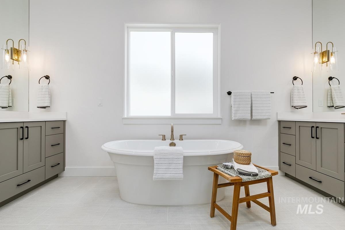 Bathroom with vanity, a soaking tub, and light tile patterned floors
