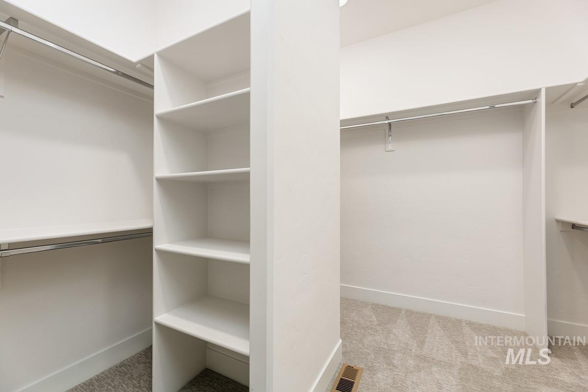 Spacious closet featuring light colored carpet