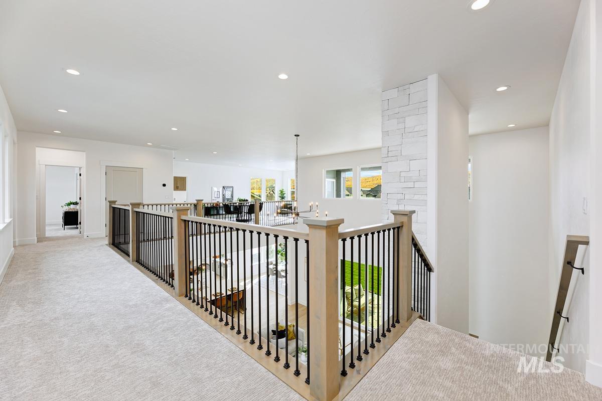 Hallway with an upstairs landing, recessed lighting, and carpet