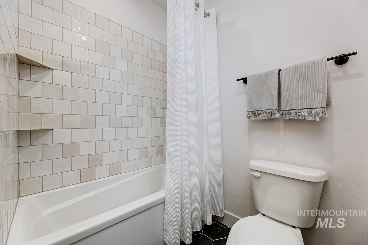 Full bathroom with toilet and shower / bath combo