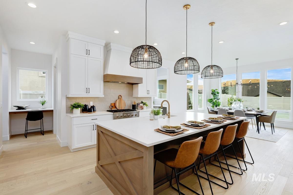 Kitchen featuring white cabinets, tasteful backsplash, light wood finished floors, and recessed lighting