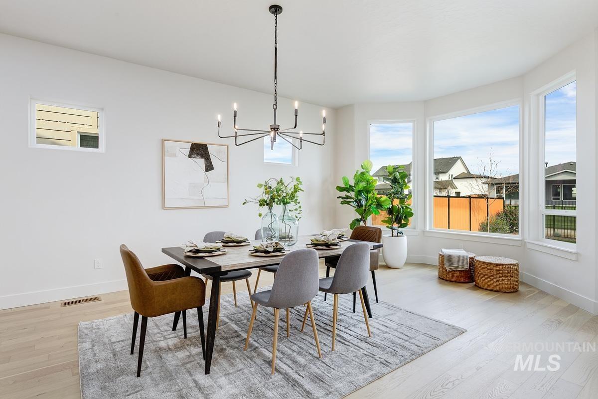 Dining area featuring light wood-type flooring and a chandelier