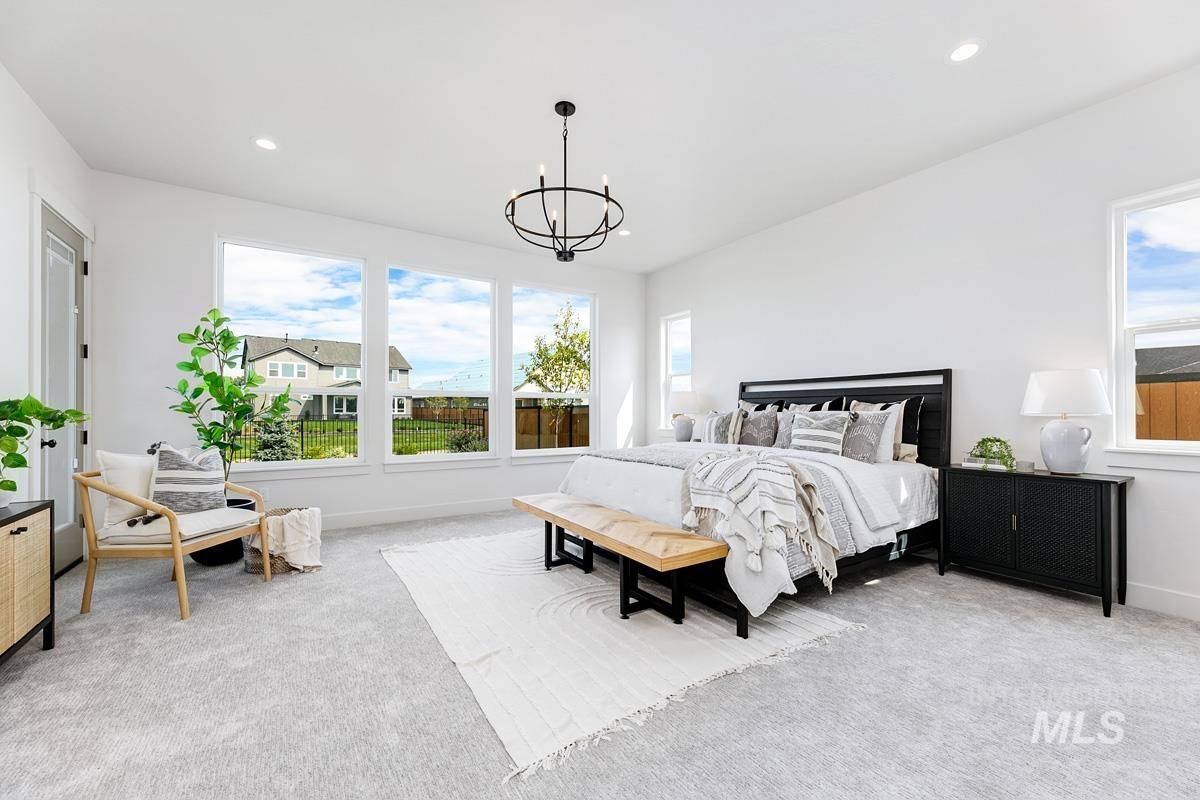 Bedroom with light carpet, multiple windows, recessed lighting, and a chandelier