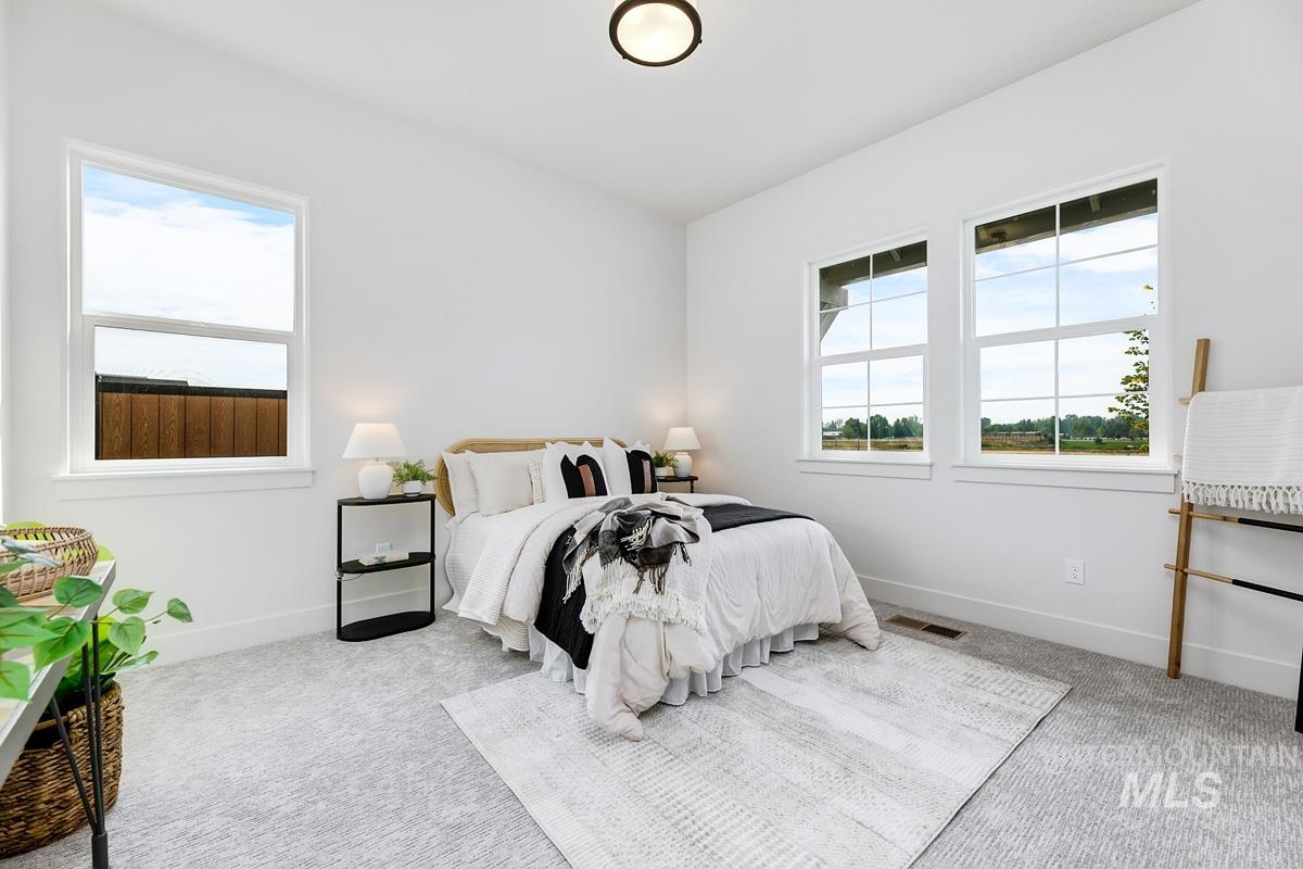 Bedroom with carpet floors and multiple windows