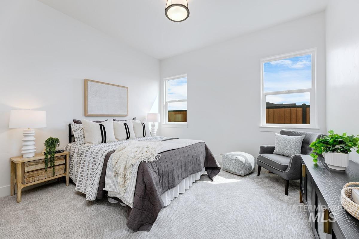 Bedroom with multiple windows and light colored carpet