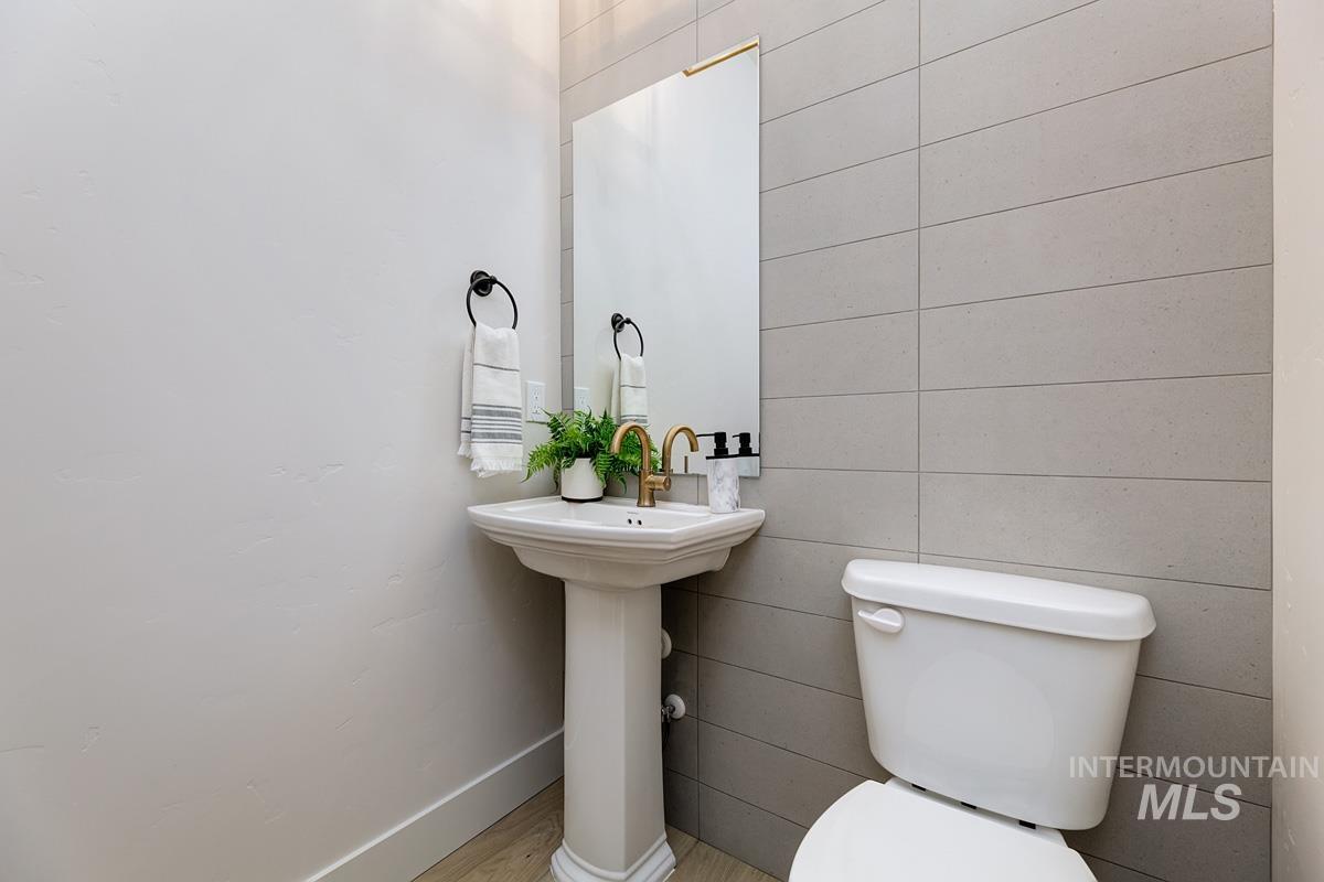 Half bath featuring baseboards and toilet