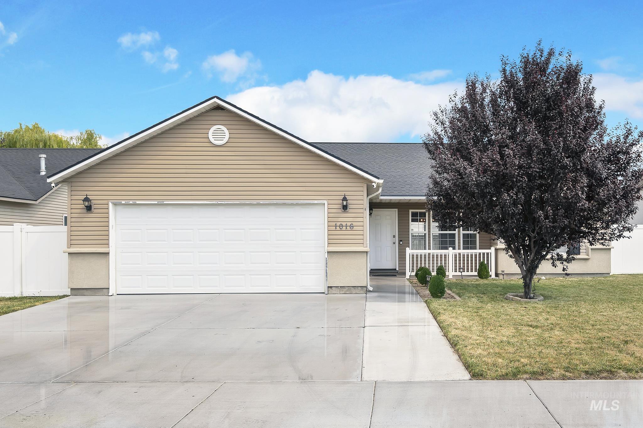 Ranch-style house featuring a porch, driveway, and a garage