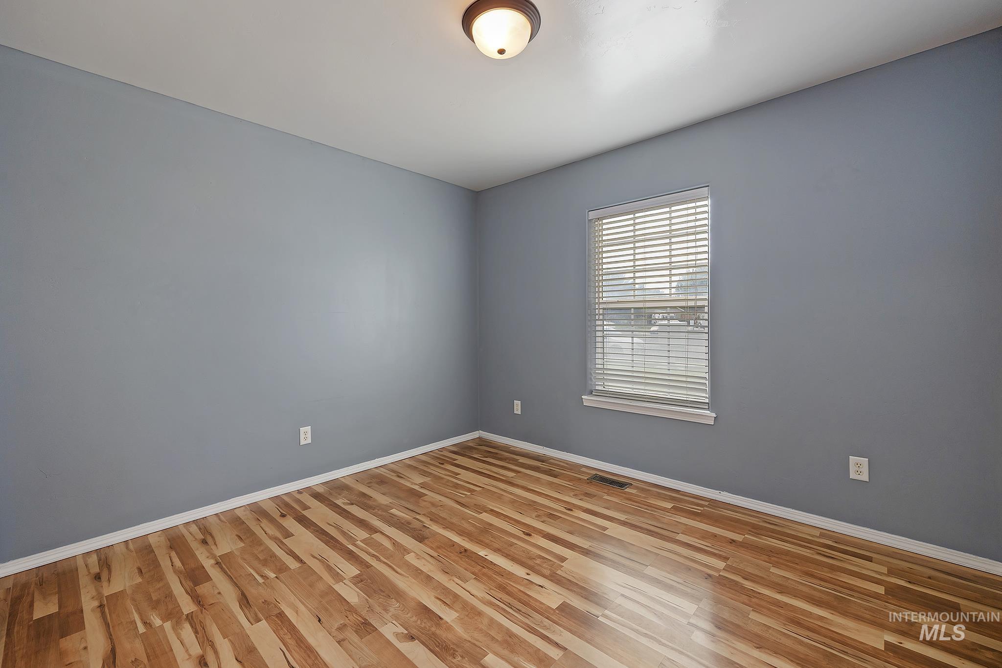 Empty room with light wood finished floors and baseboards
