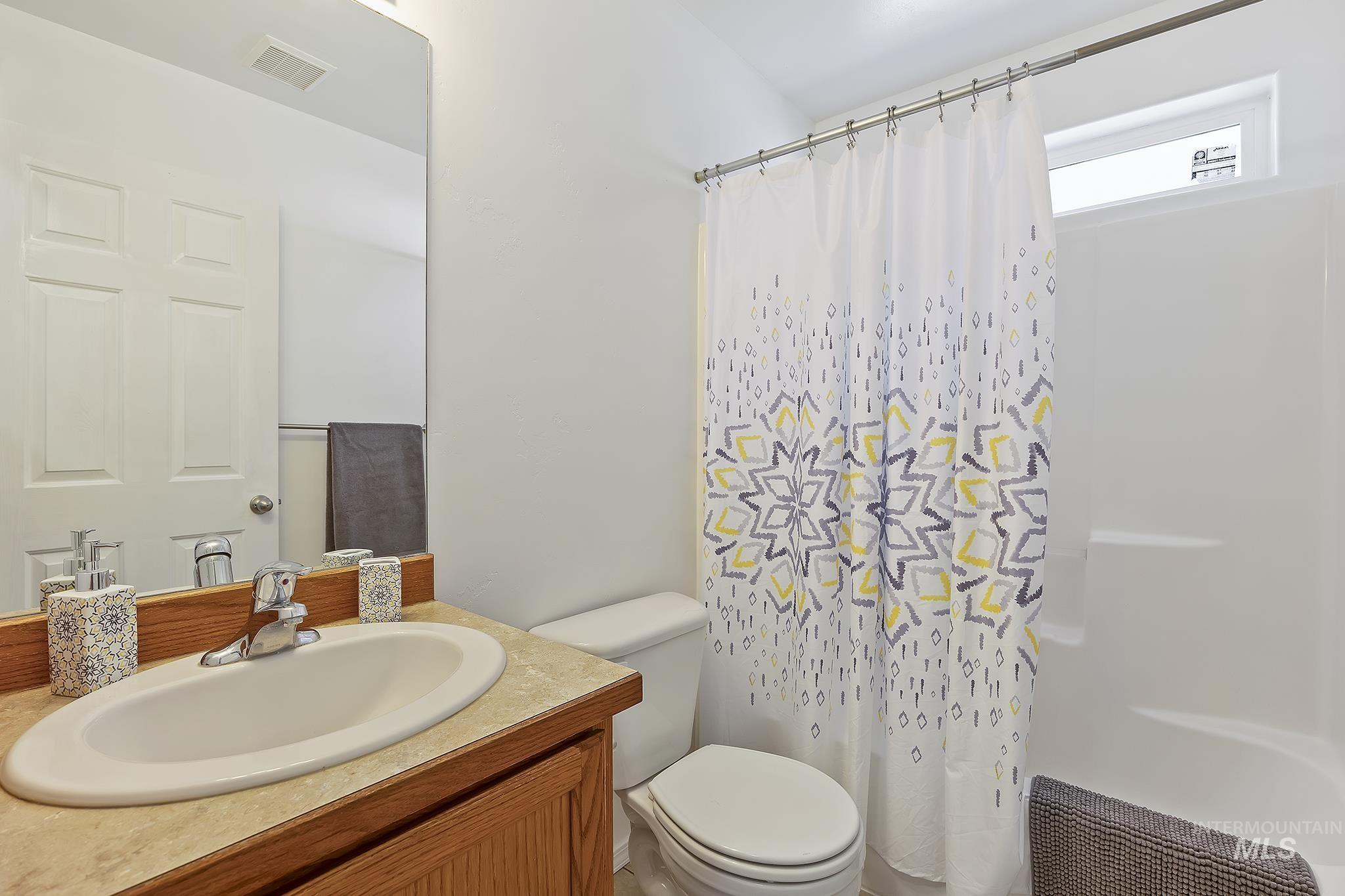 Full bath featuring vanity and curtained shower