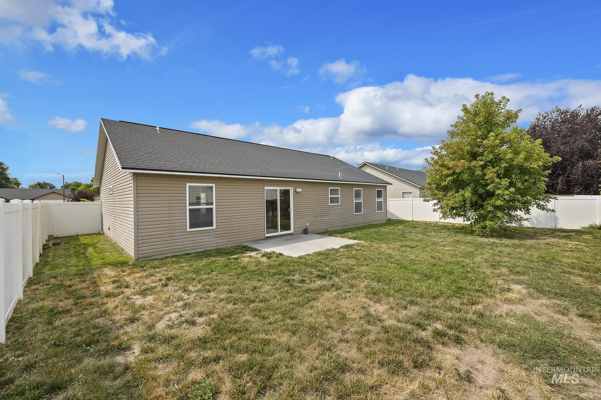 Back of house featuring a patio area, a fenced backyard, and roof with shingles