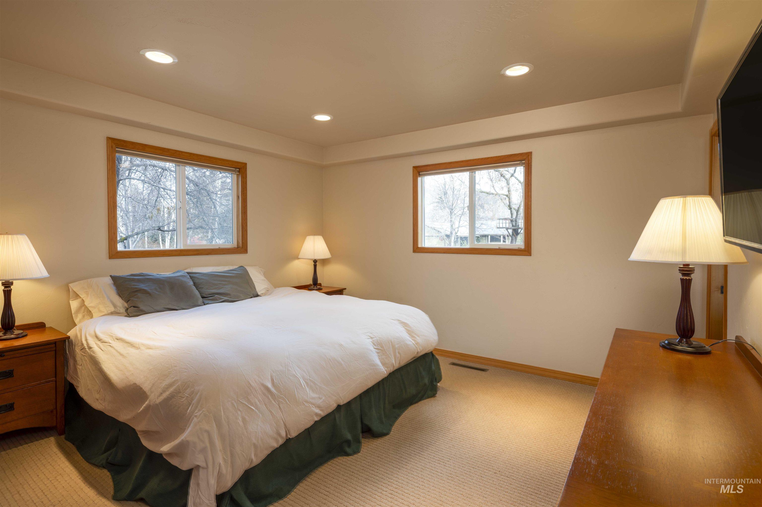 Bedroom with multiple windows, carpet floors, and recessed lighting