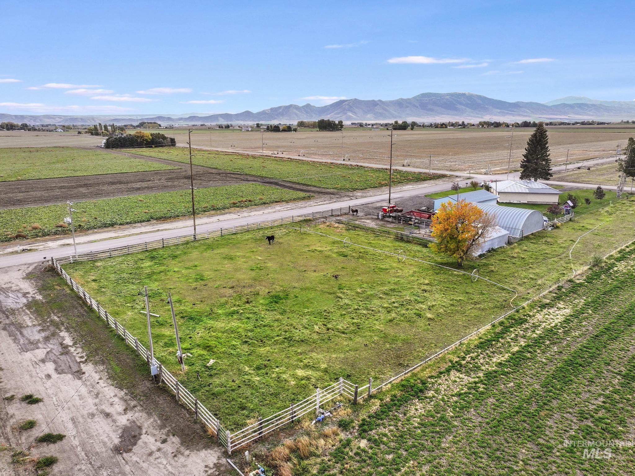 View of rural area with large plots for crops and a mountain backdrop