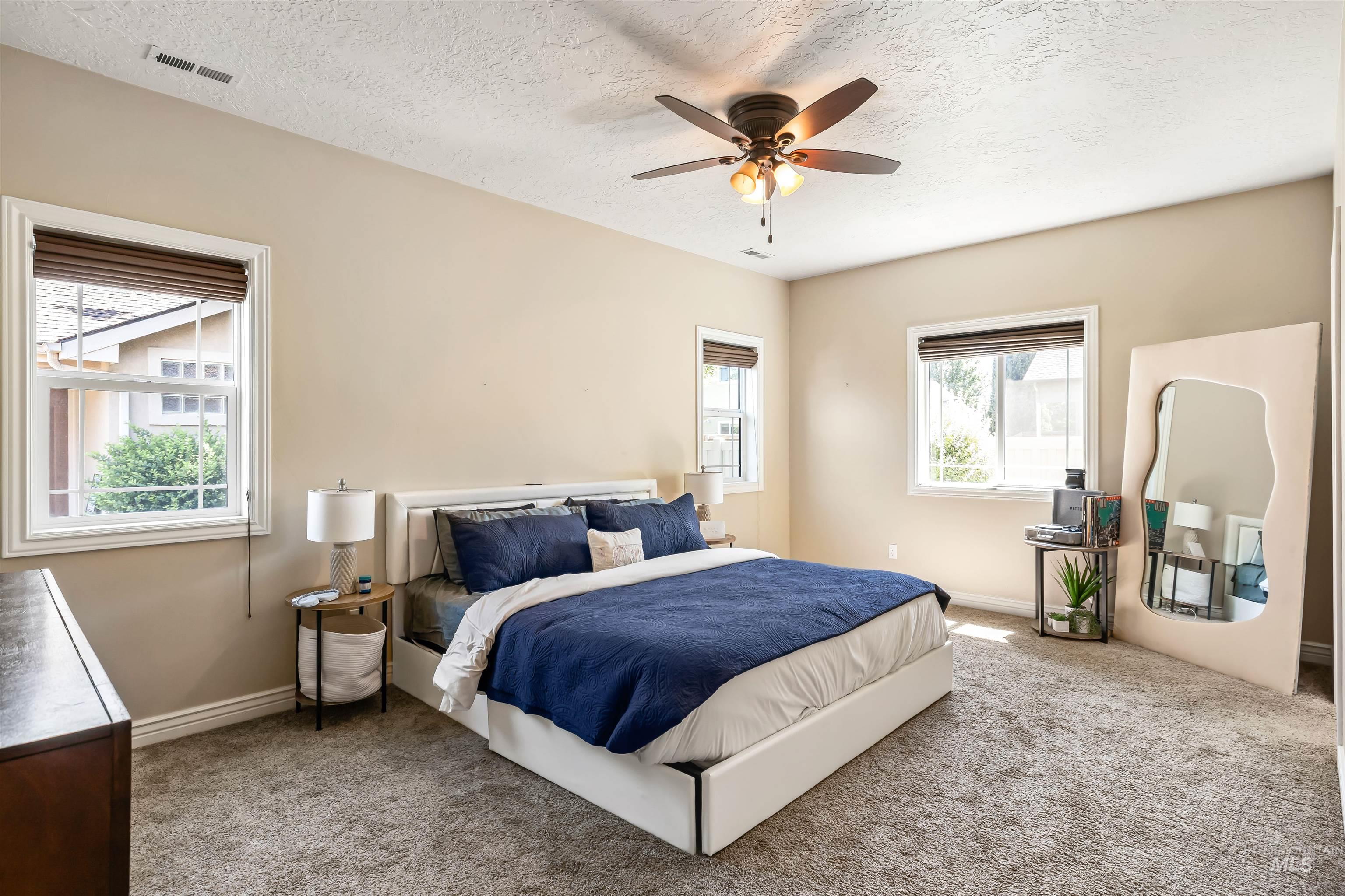 Bedroom featuring carpet flooring, ceiling fan, and a textured ceiling