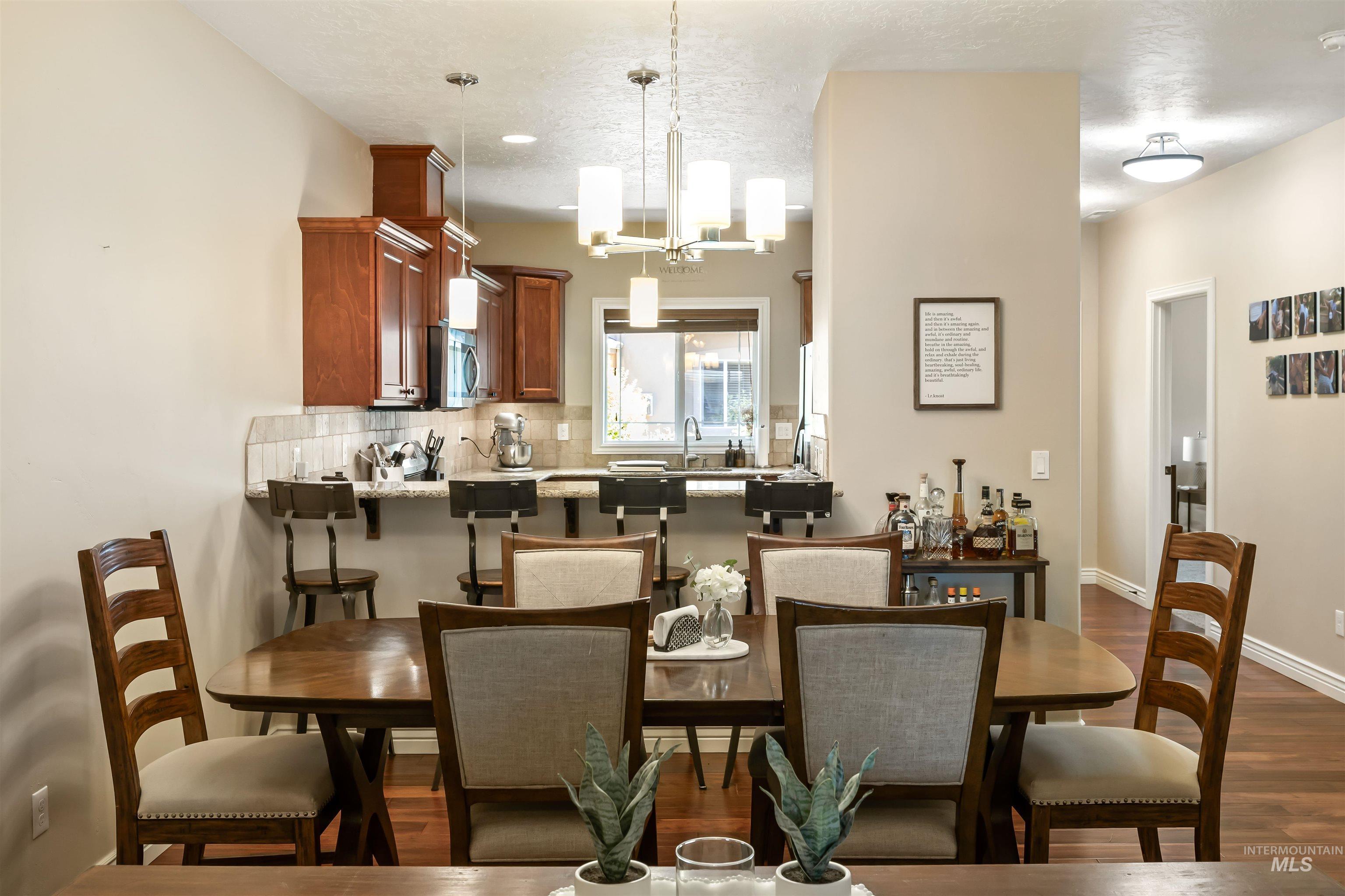 Dining area featuring dark wood finished floors and a chandelier