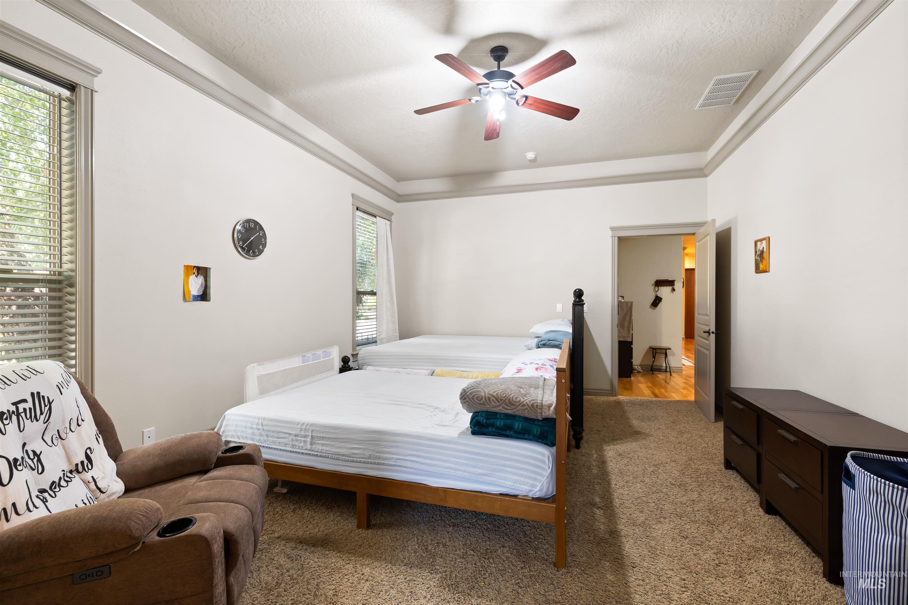 Bedroom featuring light colored carpet, a ceiling fan, and a textured ceiling
