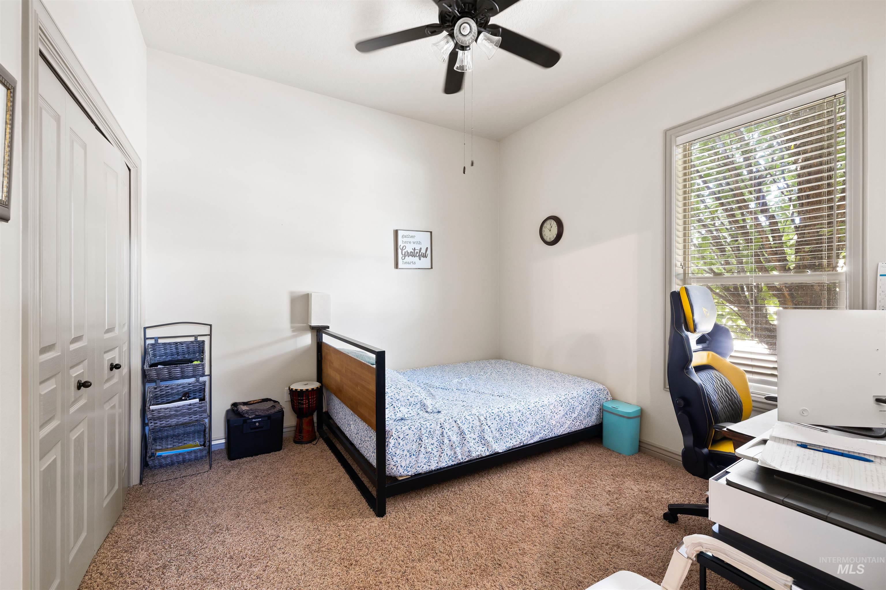 Bedroom featuring carpet floors, a closet, ceiling fan, and a desk