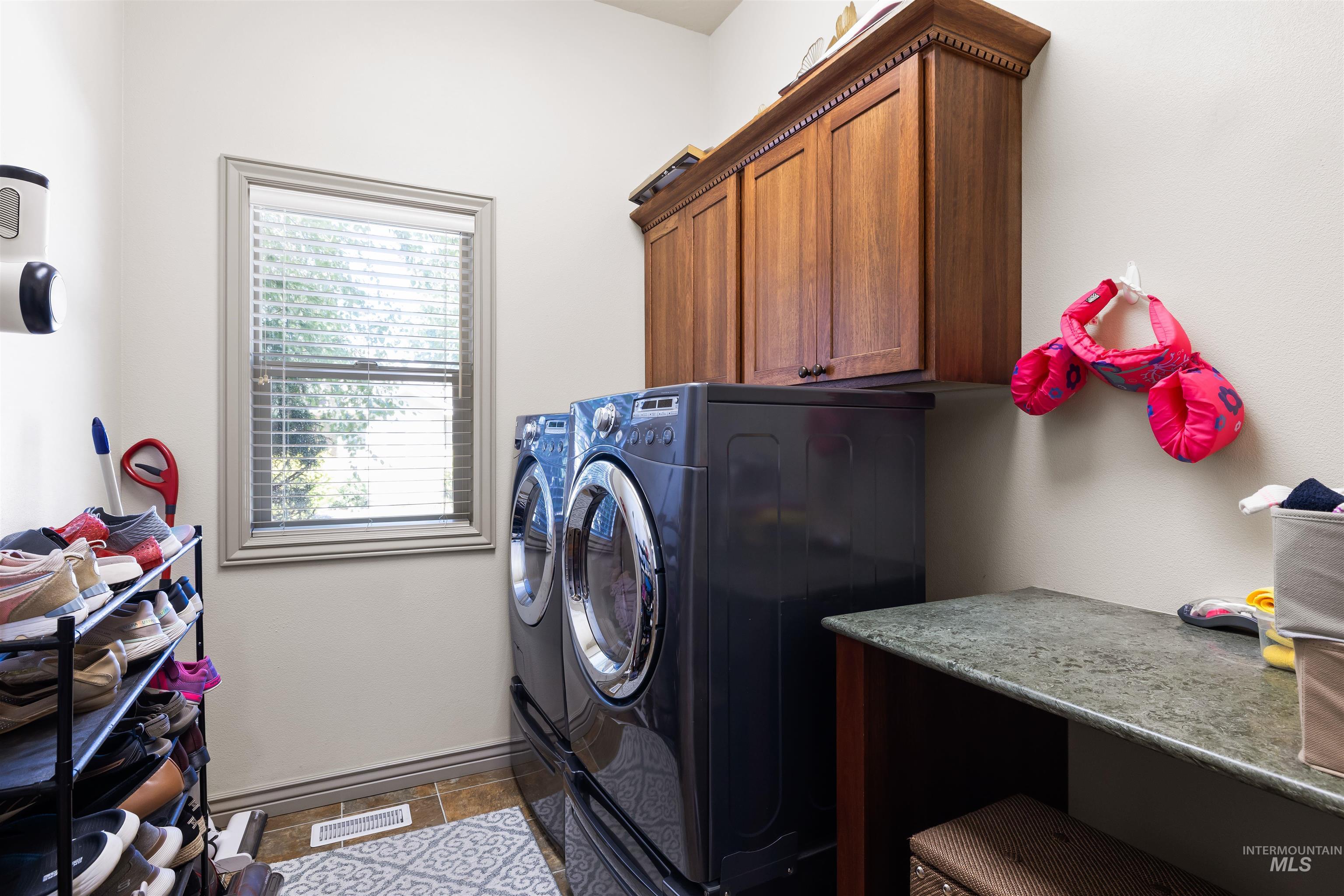 Washroom with washer and clothes dryer and cabinet space