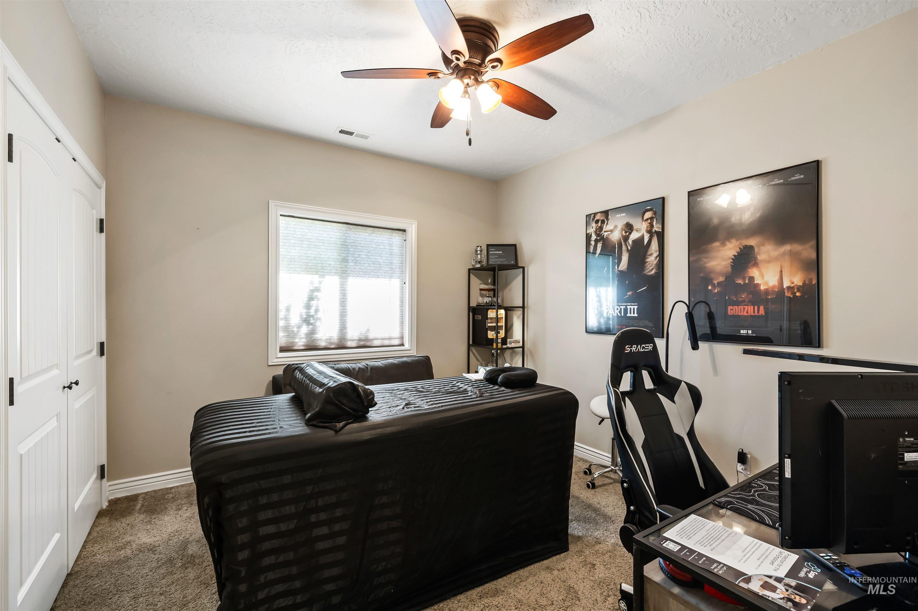 Office with carpet and a ceiling fan