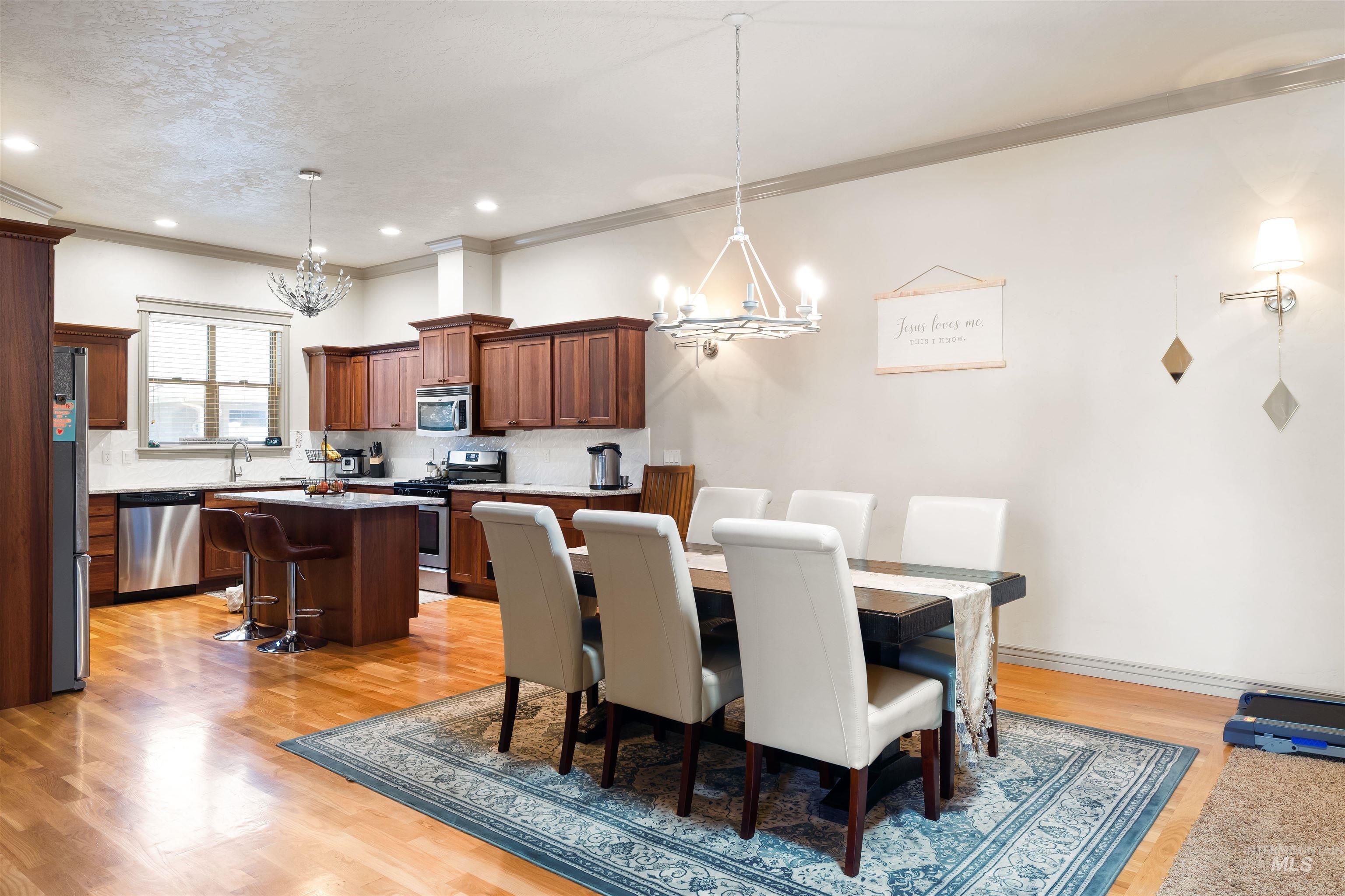 Dining space featuring a chandelier, light wood-type flooring, crown molding, and recessed lighting