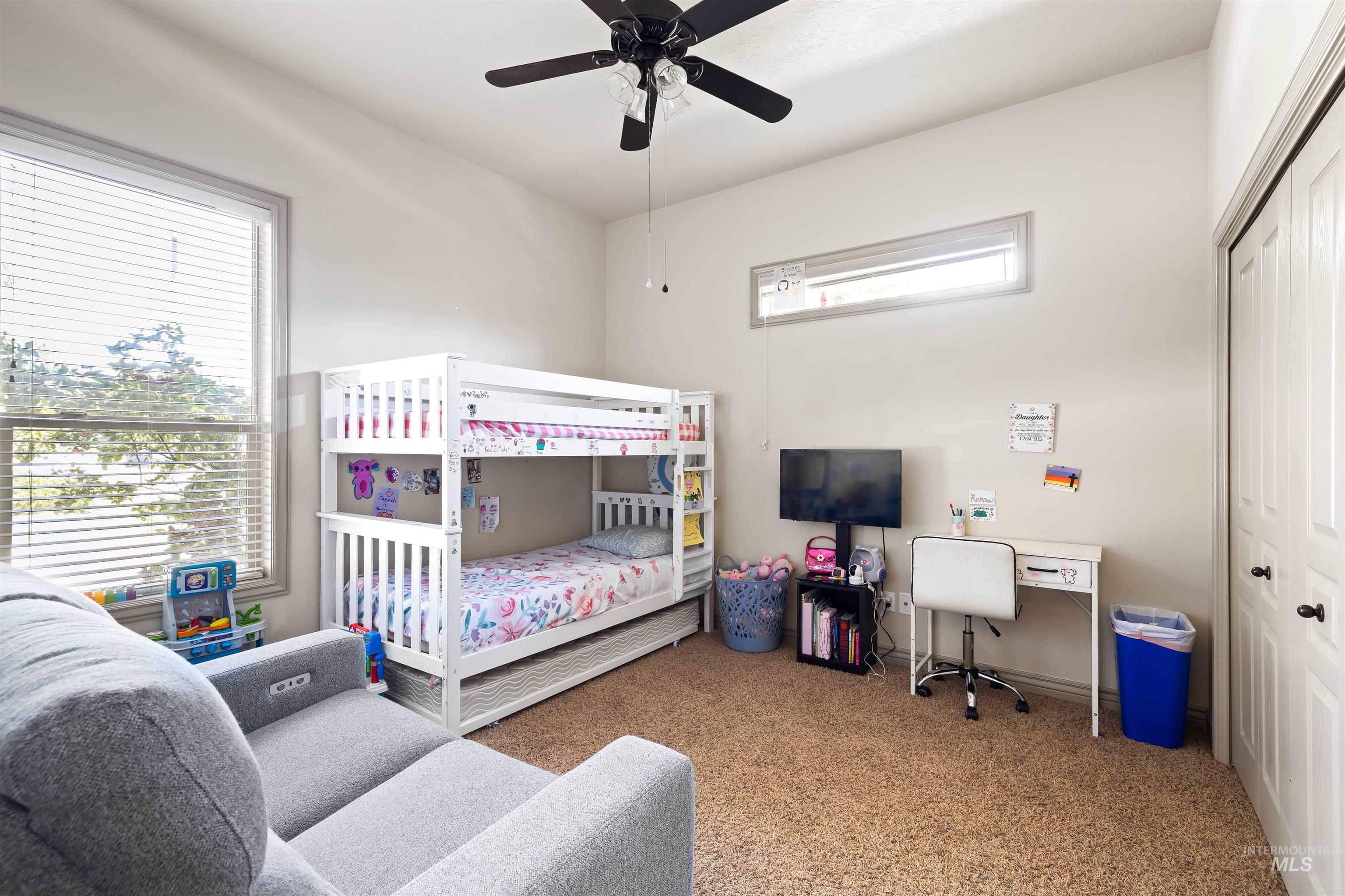 Carpeted bedroom featuring a ceiling fan and a closet