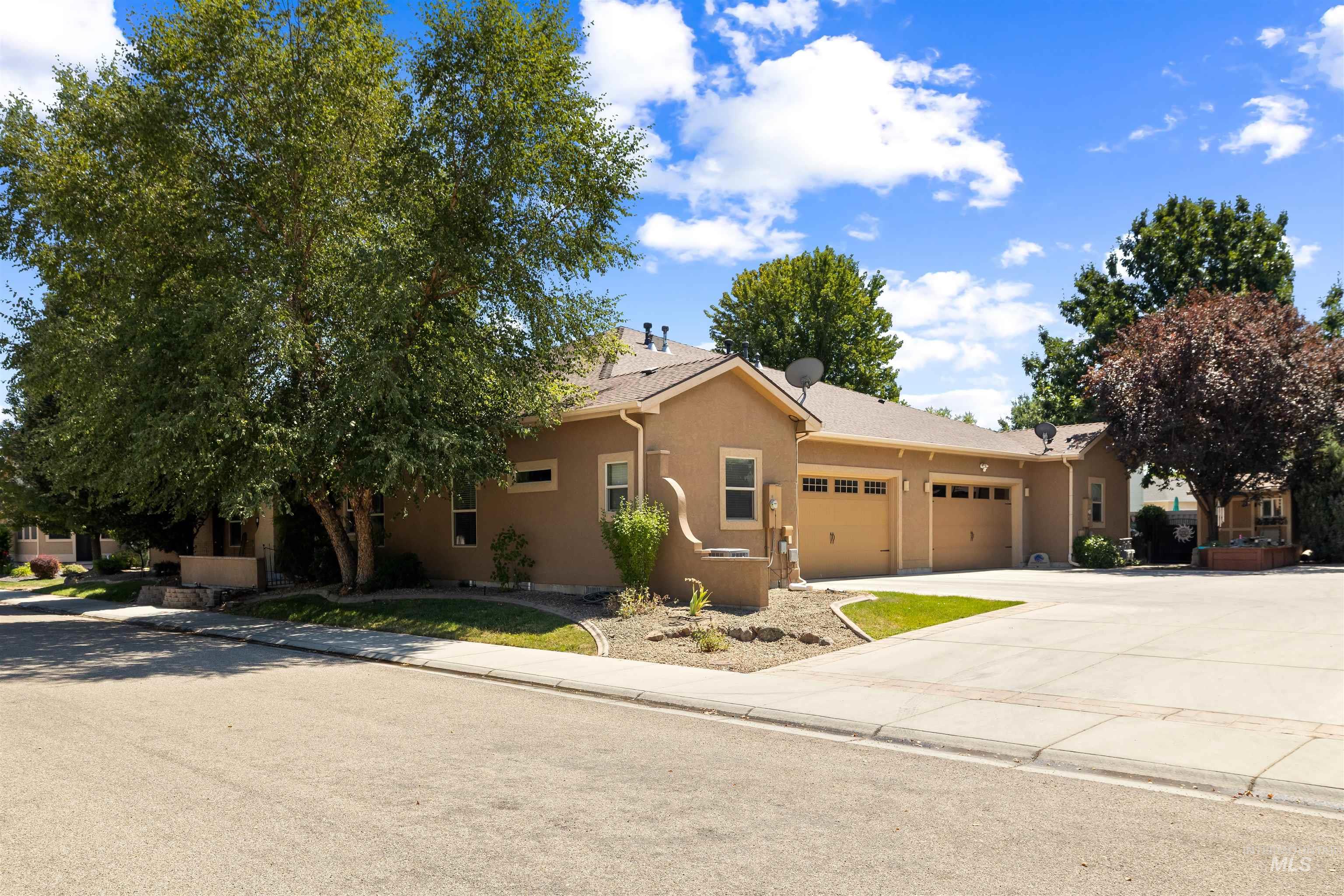 Single story home featuring concrete driveway, an attached garage, and stucco siding