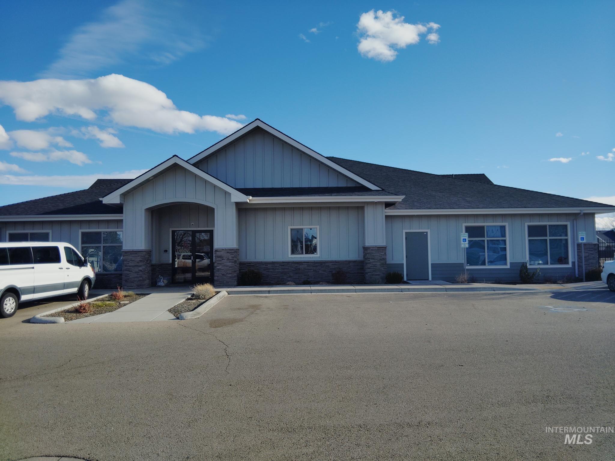 Craftsman-style home featuring stone siding, board and batten siding, and roof with shingles