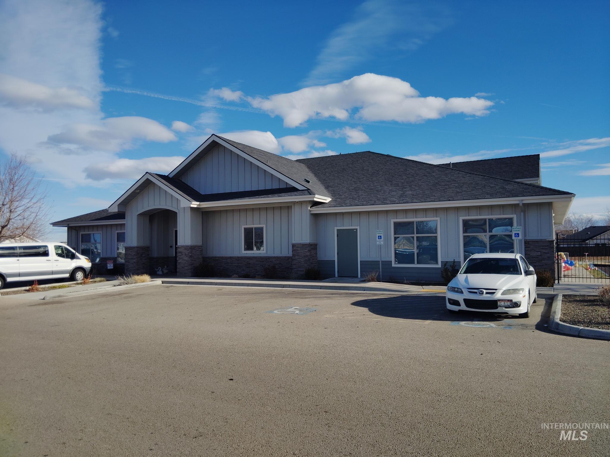 Craftsman inspired home featuring board and batten siding, roof with shingles, and stone siding
