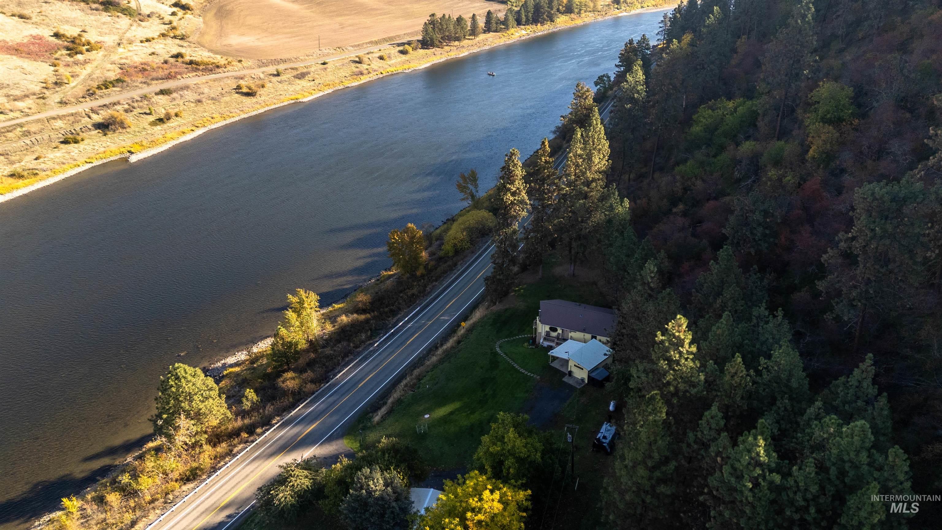 Aerial view of property and surrounding area featuring a nearby body of water