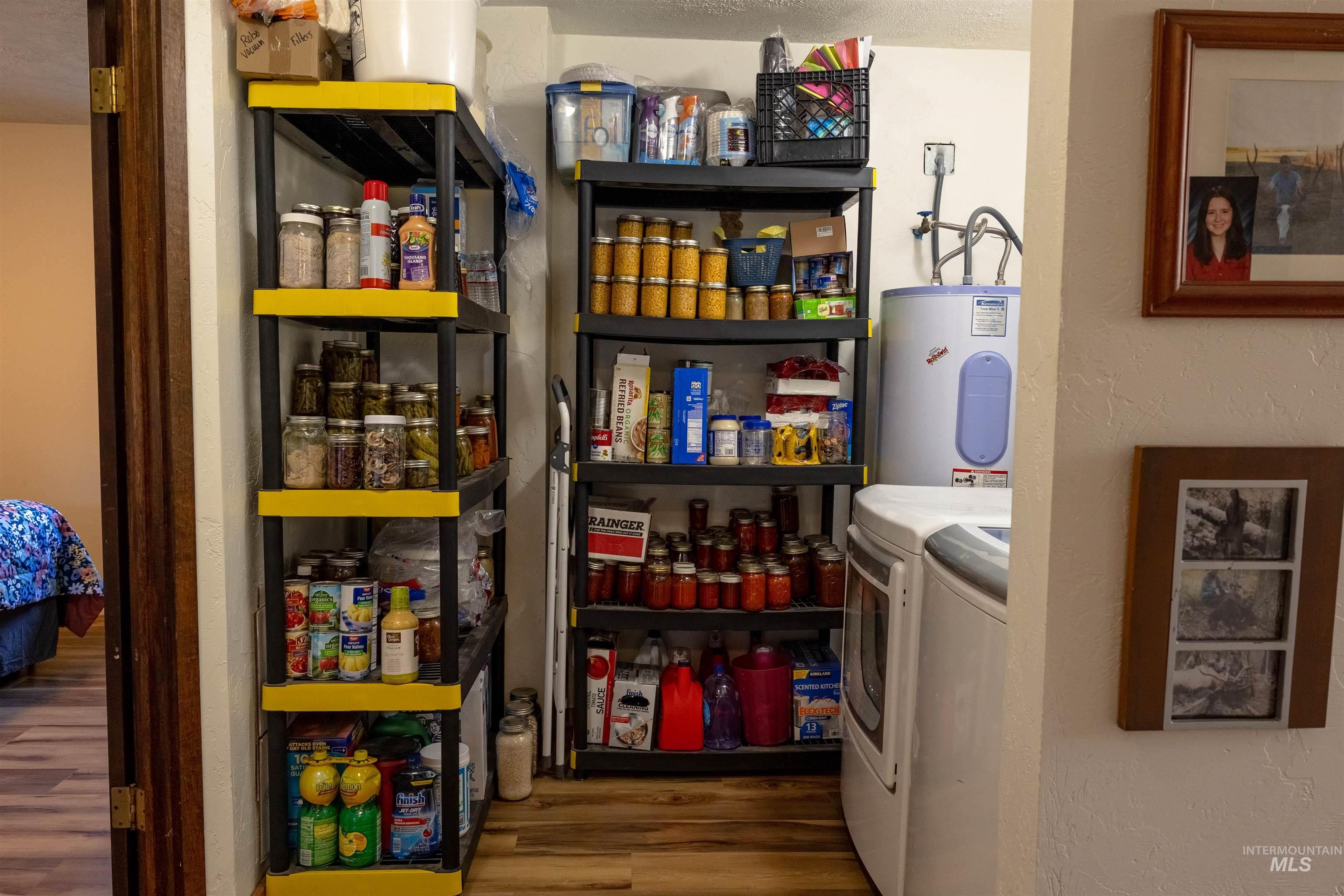 Pantry featuring water heater and separate washer and dryer