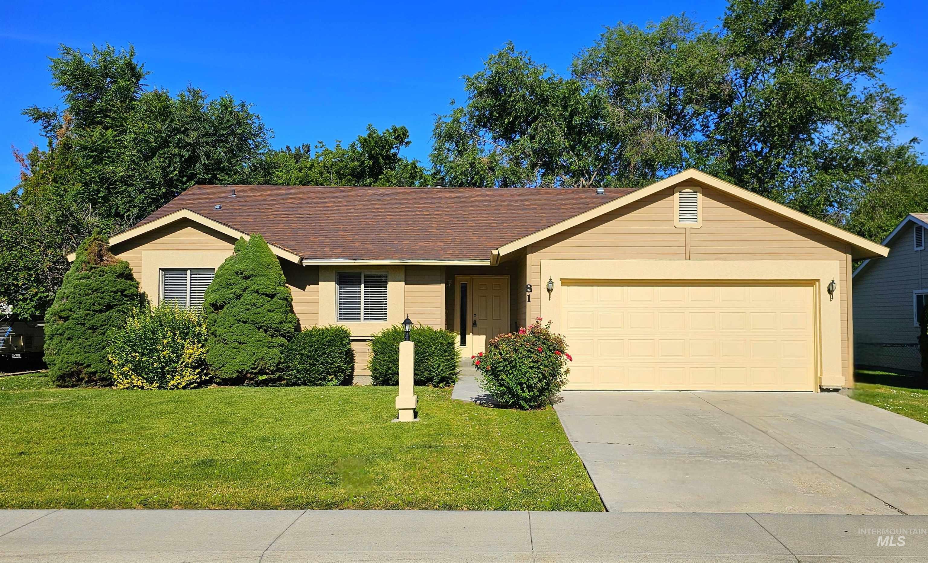 Ranch-style house with concrete driveway, a garage, and a front lawn